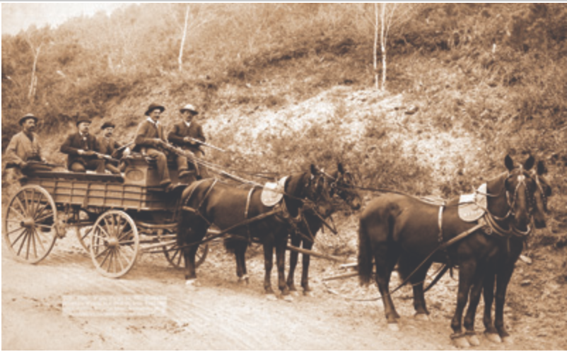 Guards brandish weapons on a Wells Fargo wagon
